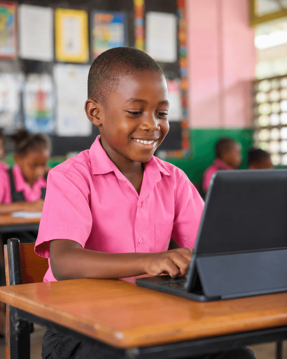 A Calvary student smiling while using a tablet in class