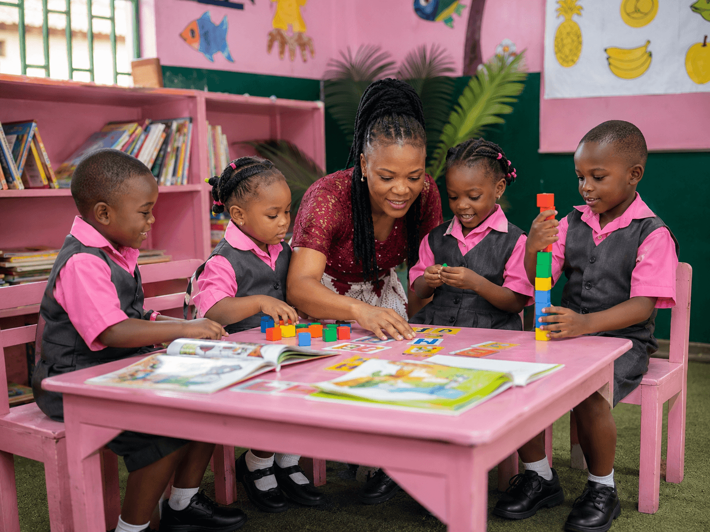 A teacher guiding young Calvary nursery students through play-based learning with blocks